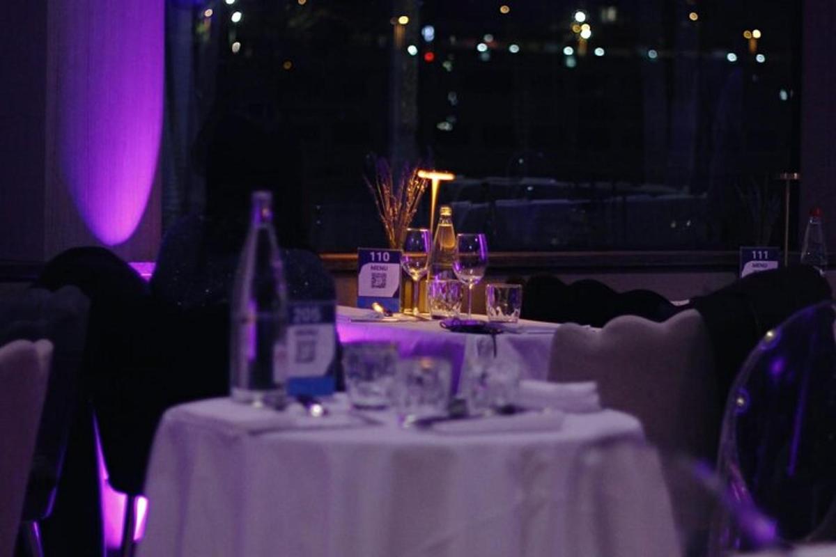 a table with bottles and glasses on it with purple lights