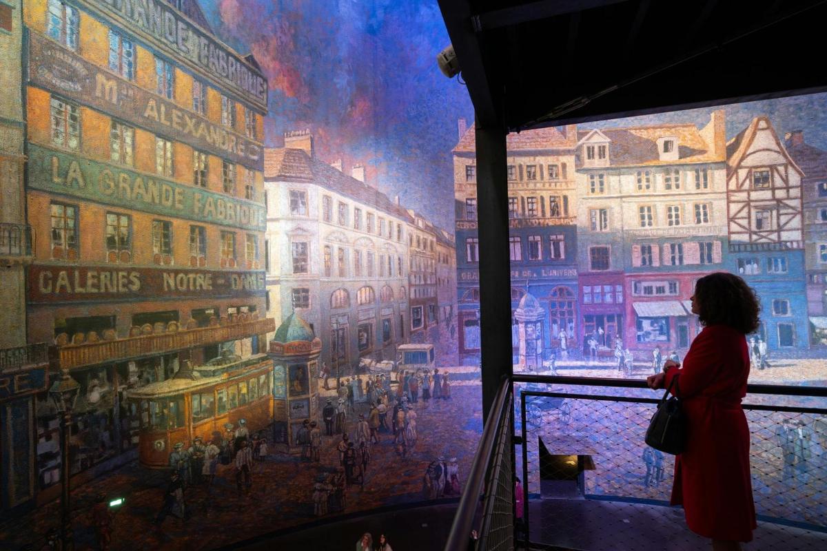 a woman standing in front of a painting of a city