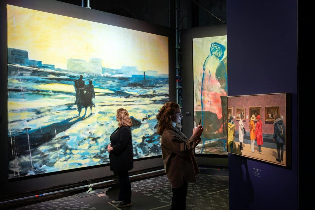 two people looking at a painting in a museum