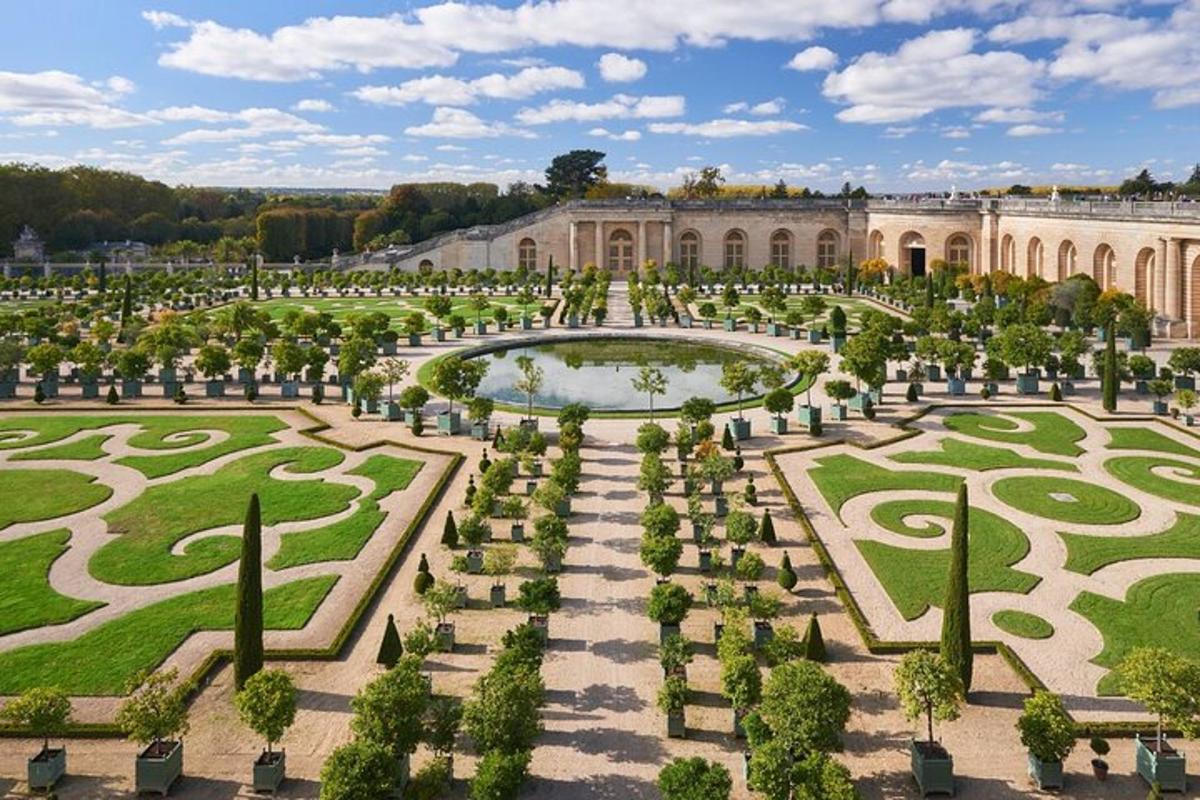 a palace with a garden with a fountain and a pond