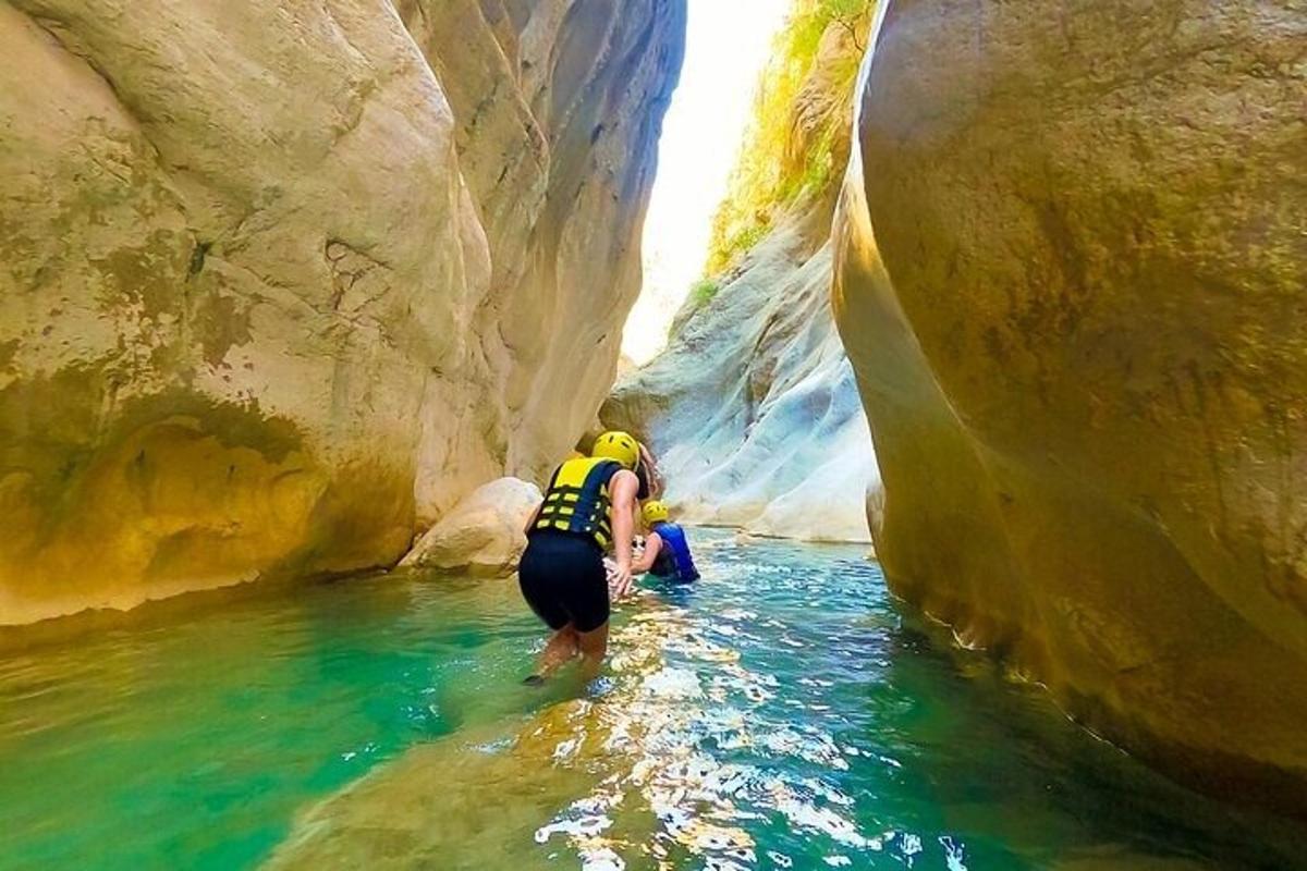 a person standing in the water in a canyon
