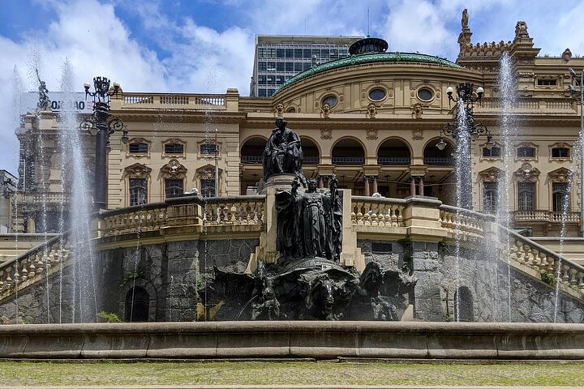 a statue in front of a building with a fountain