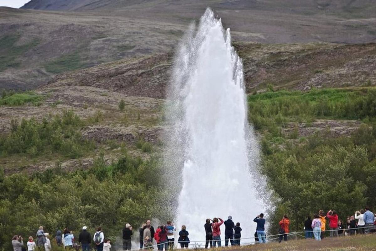 sekumpulan orang berdiri di hadapan air terjun