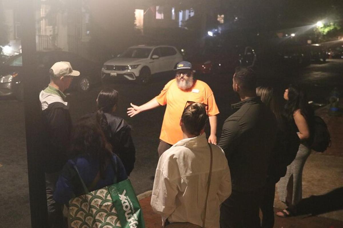 un home dret entre una multitud de gent a la nit