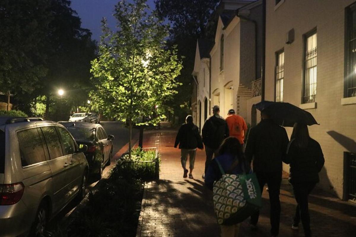 un grup de persones caminant per una vorera a la nit