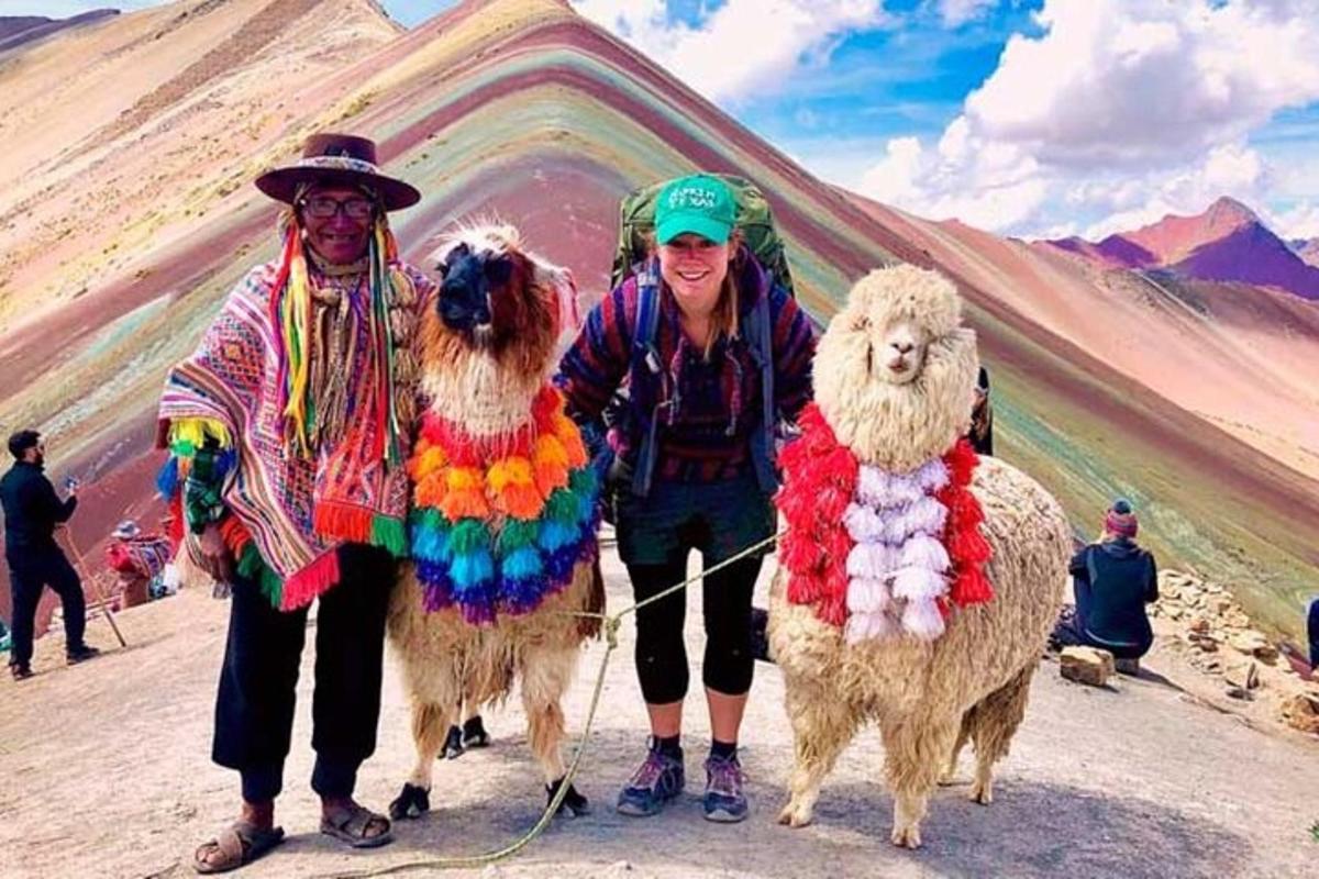 Un hombre y dos mujeres de pie junto a dos ovejas
