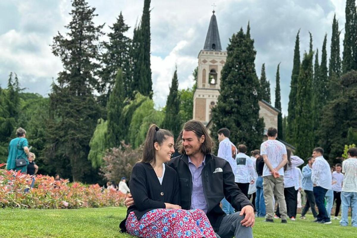 Un hombre y una mujer sentados en el césped de un parque.