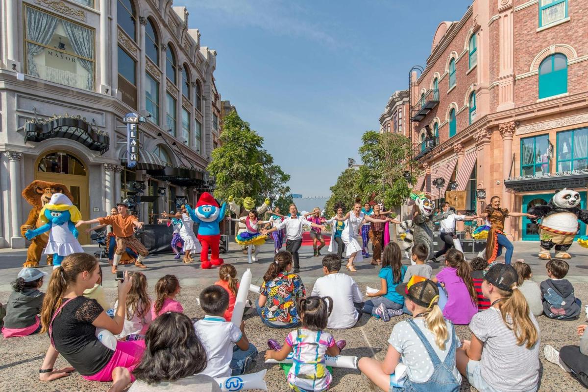 a crowd of people sitting on the street watching a parade