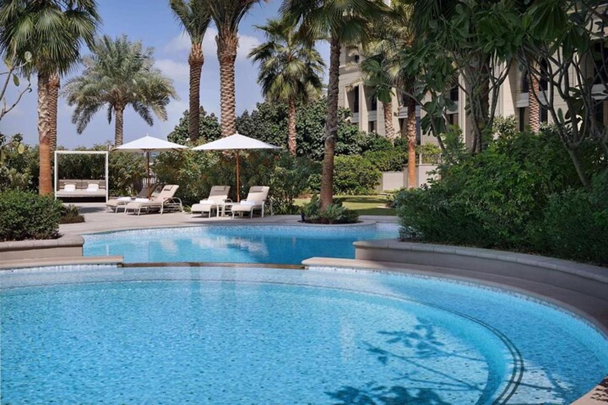 a swimming pool with palm trees and a building