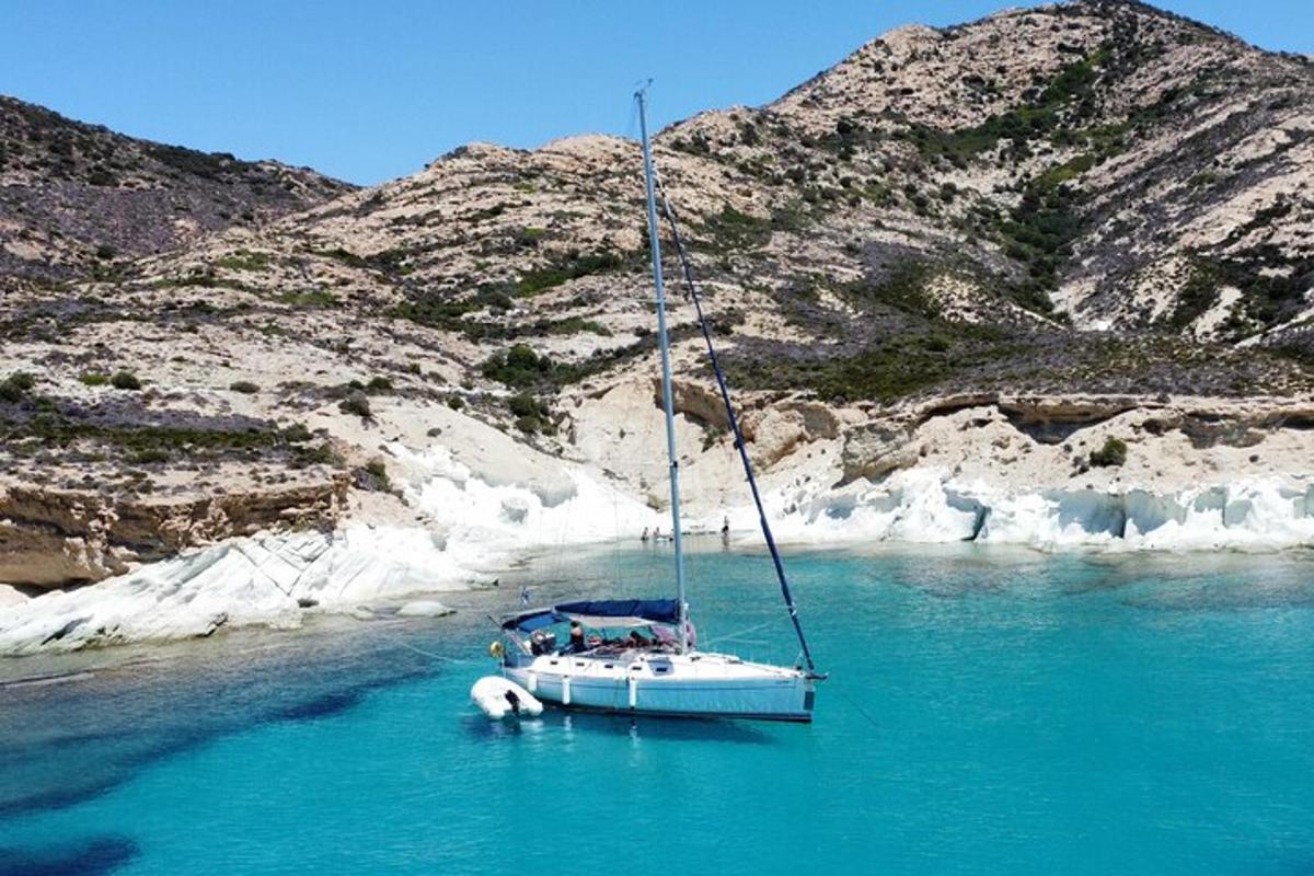 a boat in the water next to a mountain
