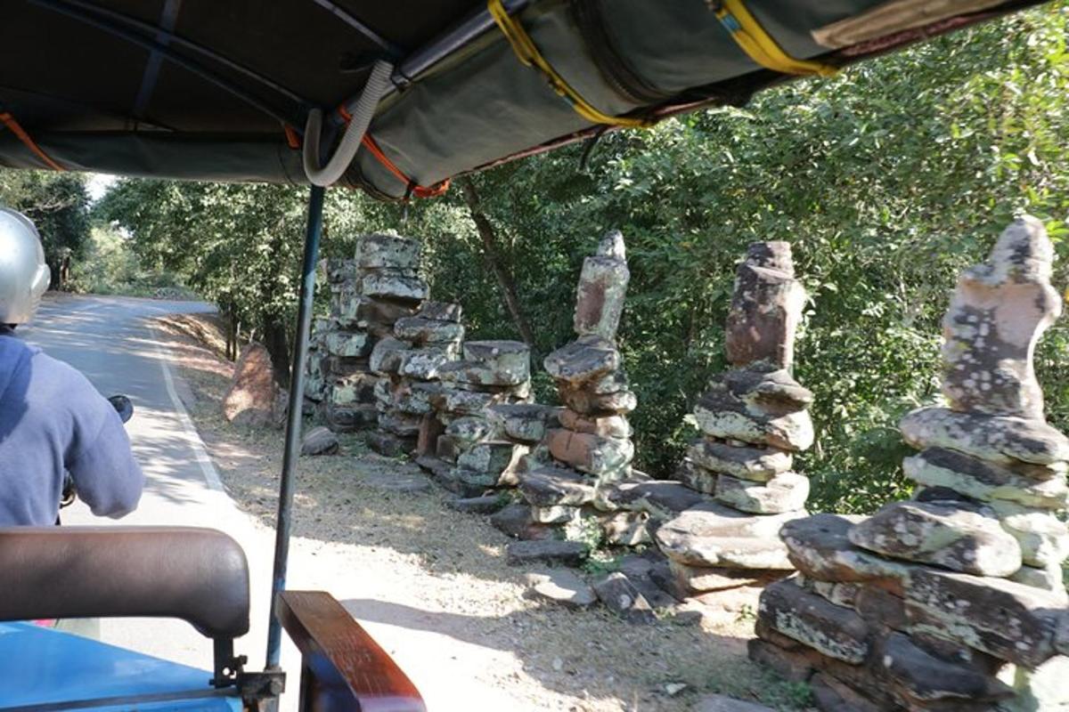 skupina kamenných věží stojící vedle autobusu