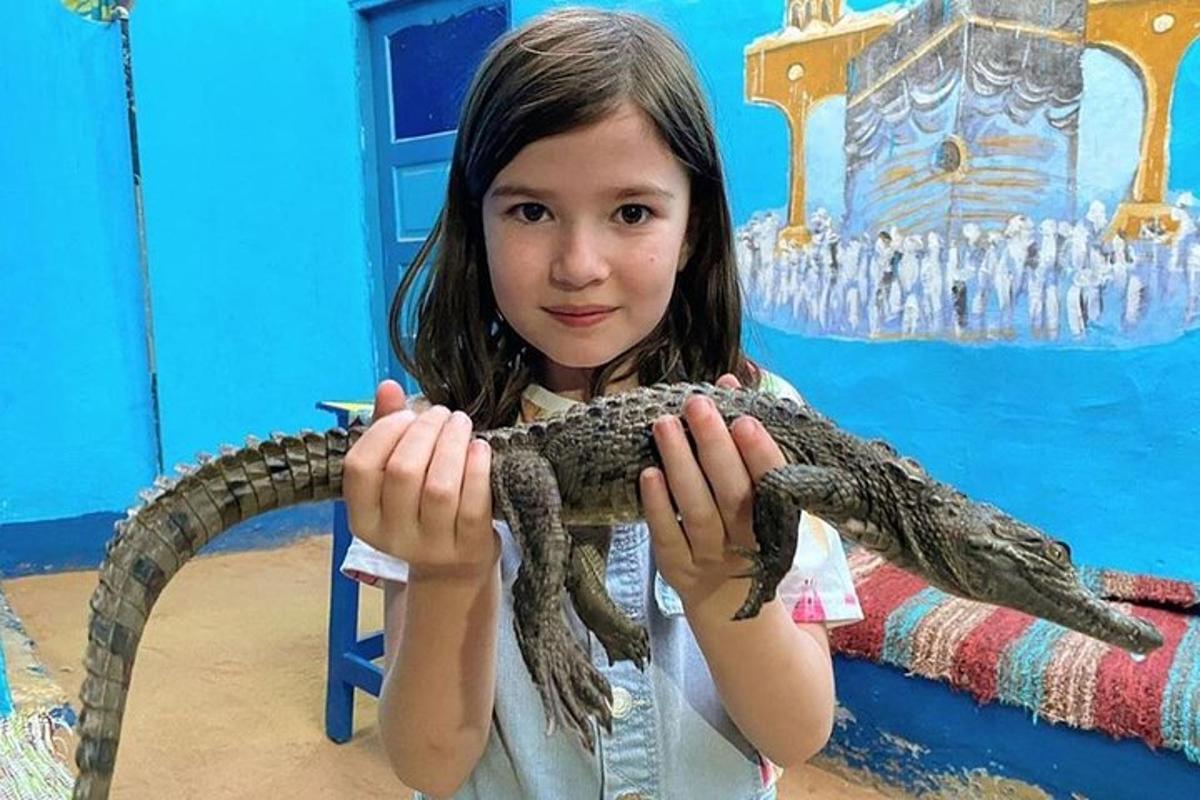 младо момиче, държащо змия в ръцете си