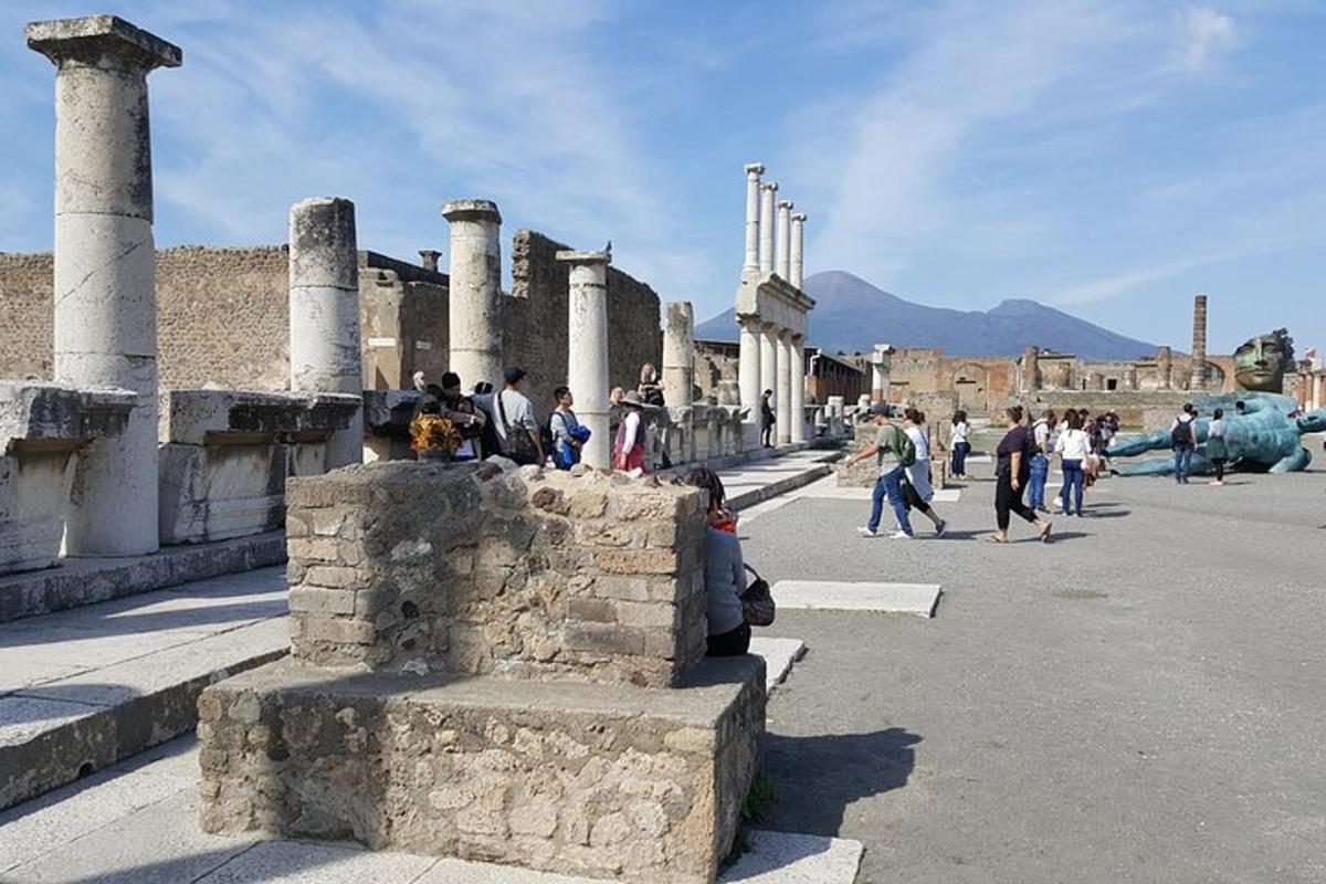a group of people walking in a street with columns