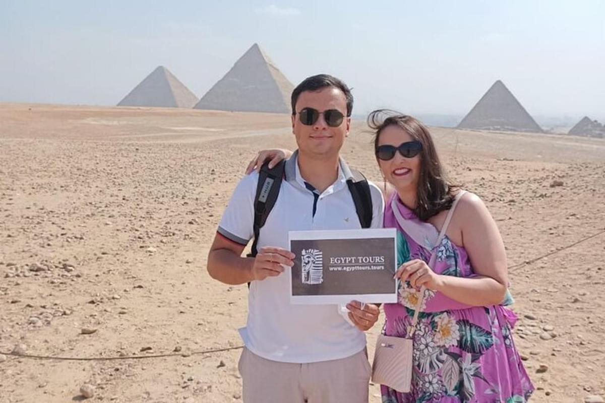 un uomo e una donna in piedi davanti alle piramidi