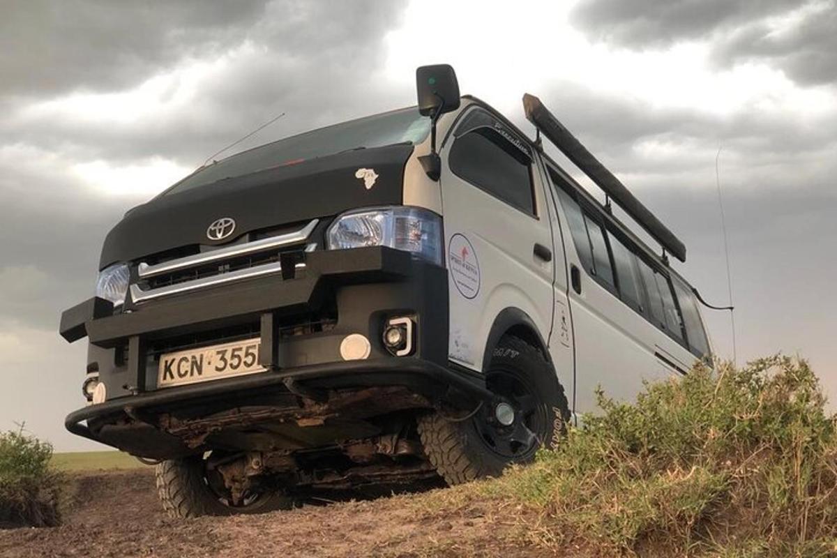 un autobus bianco e nero parcheggiato su una strada sterrata