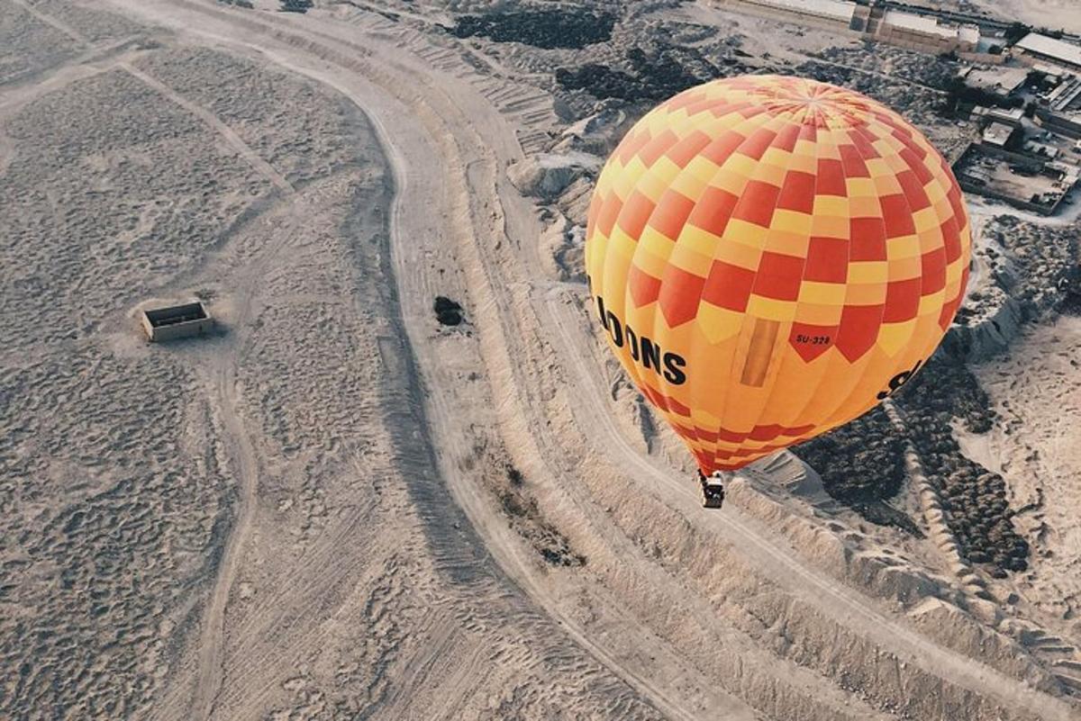 منطاد هواء ساخن أصفر وبرتقالي يحلق فوق الصحراء