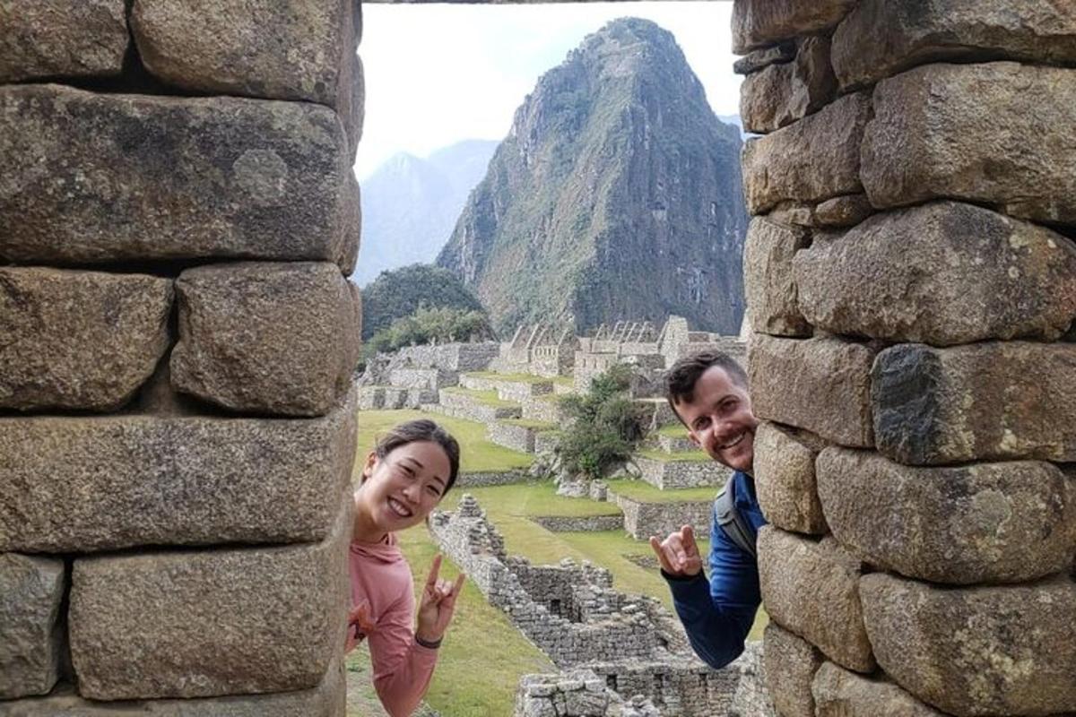 um homem e uma mulher em pé atrás de uma parede de pedra