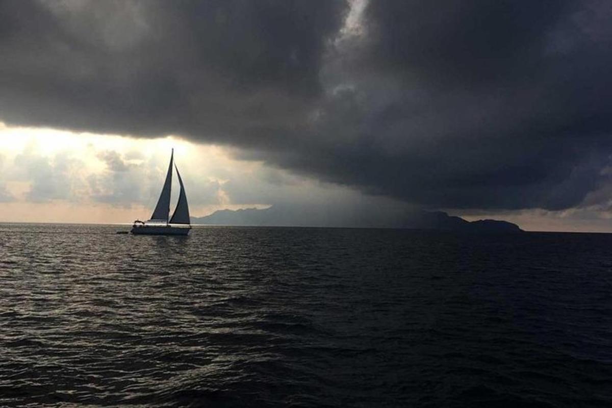 jadrnica v oceanu pod oblačnim nebom