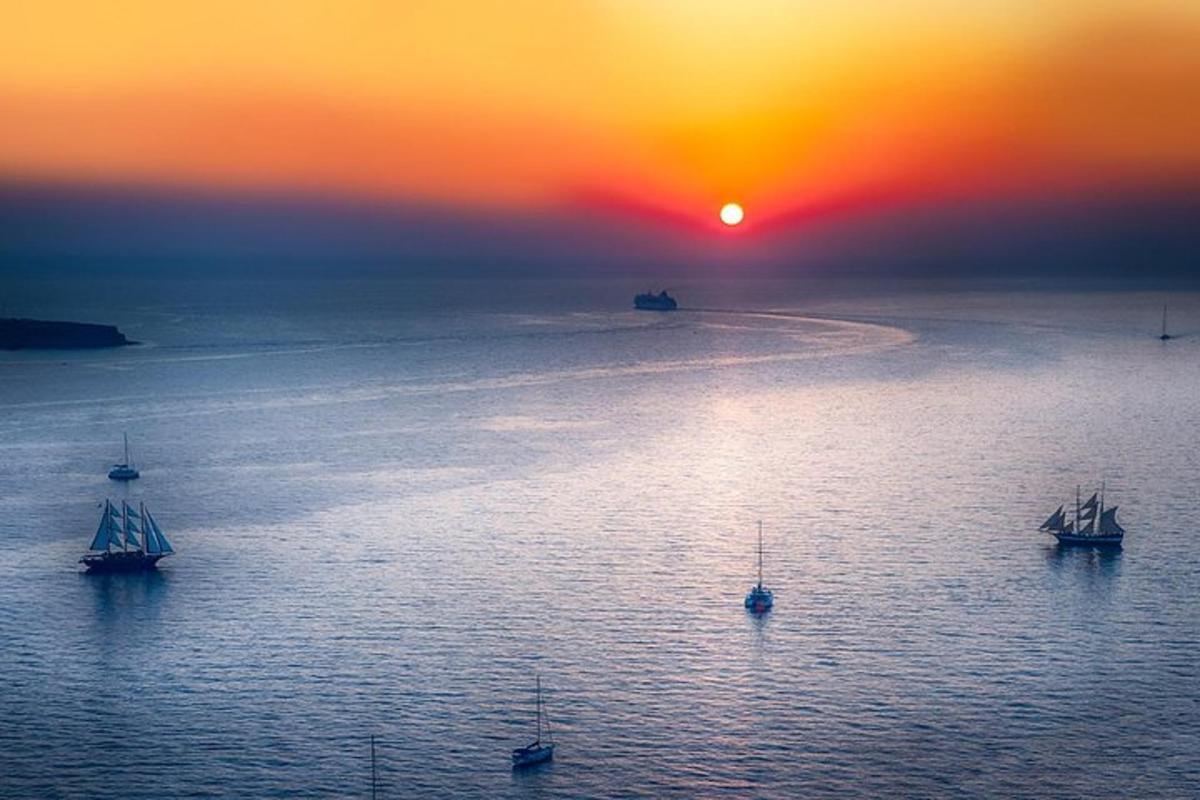 a group of boats in the water at sunset