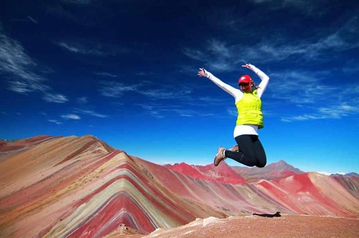 seorang wanita melompat di udara di atas gunung
