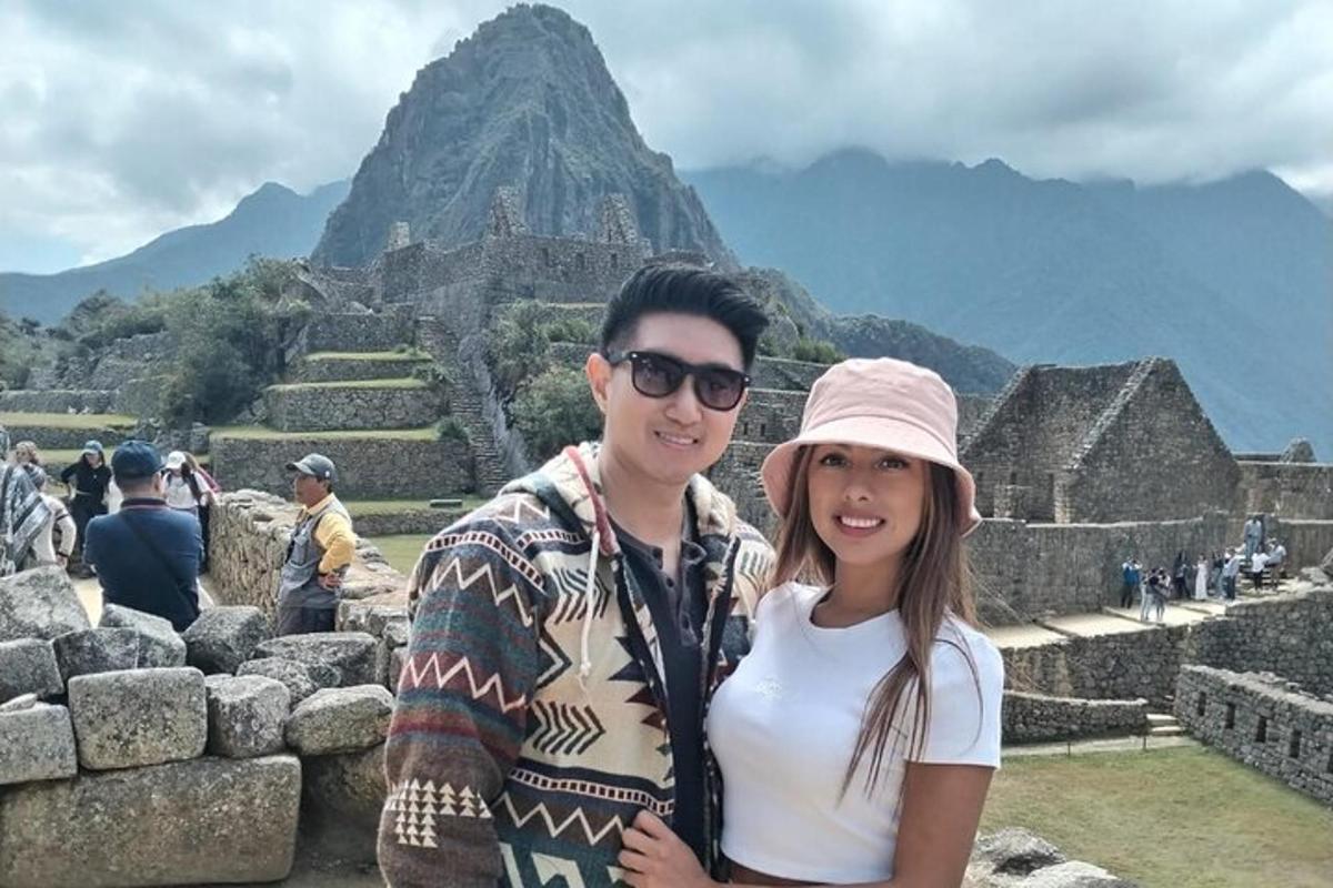 a man and a woman standing at the ruins of a pyramid