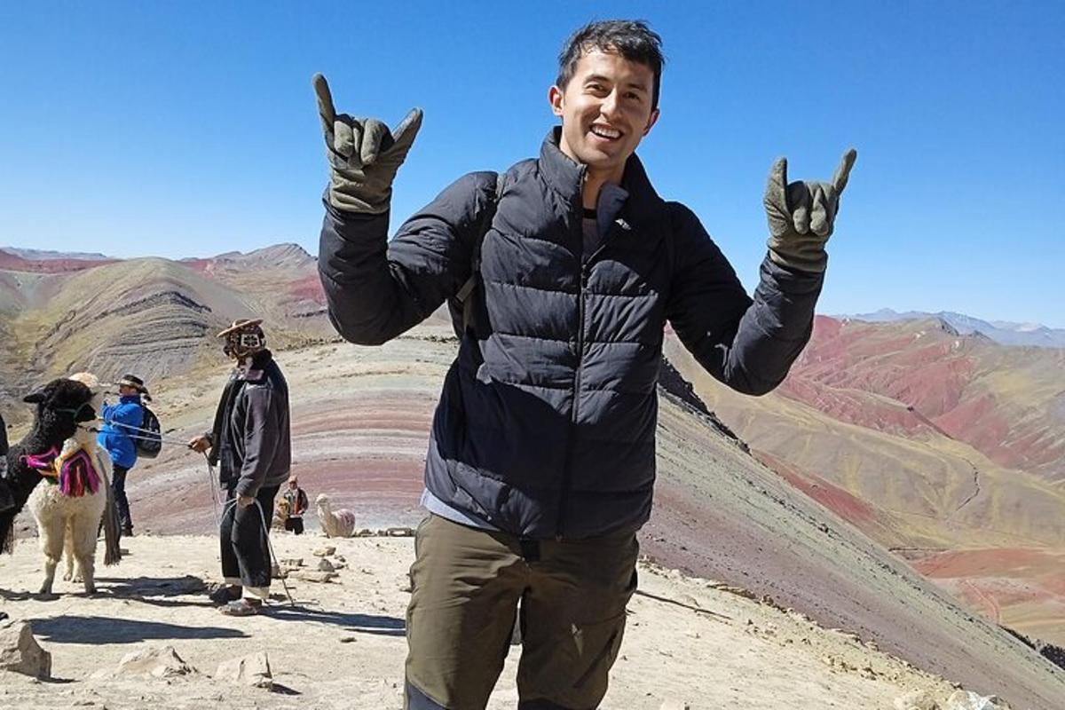 seorang lelaki mengangkat tangannya sambil berdiri di atas gunung