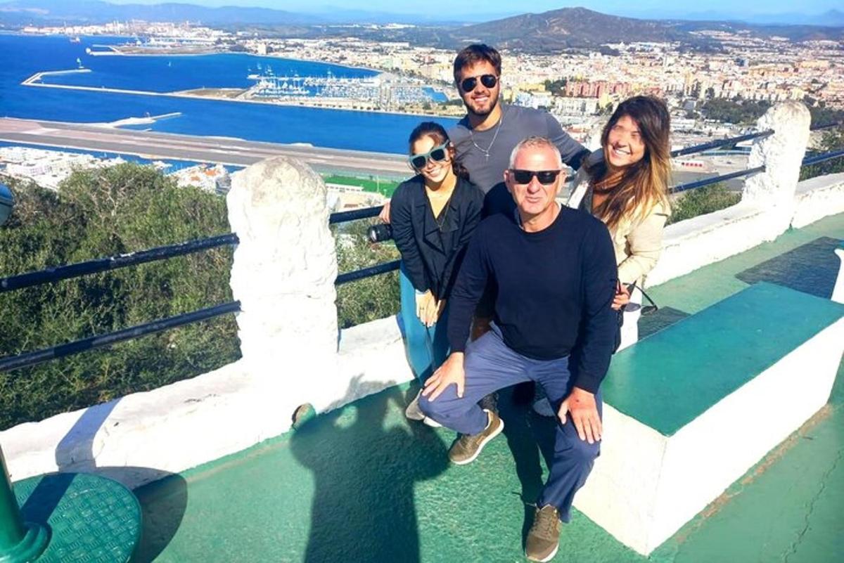a group of people posing for a picture on a ledge