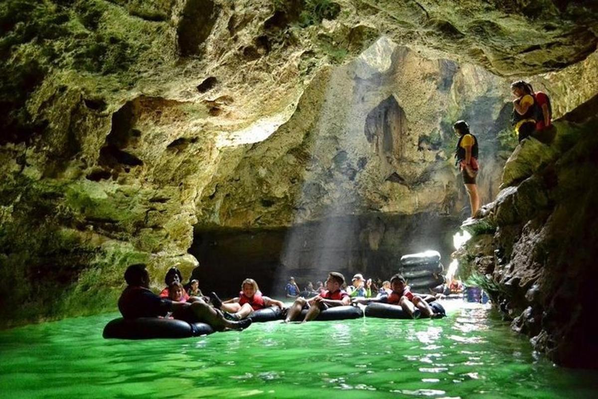 a group of people sitting in the water in a cave