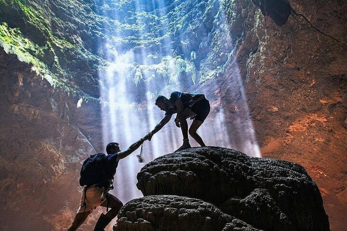 due persone si aiutano a vicenda attraverso una cascata