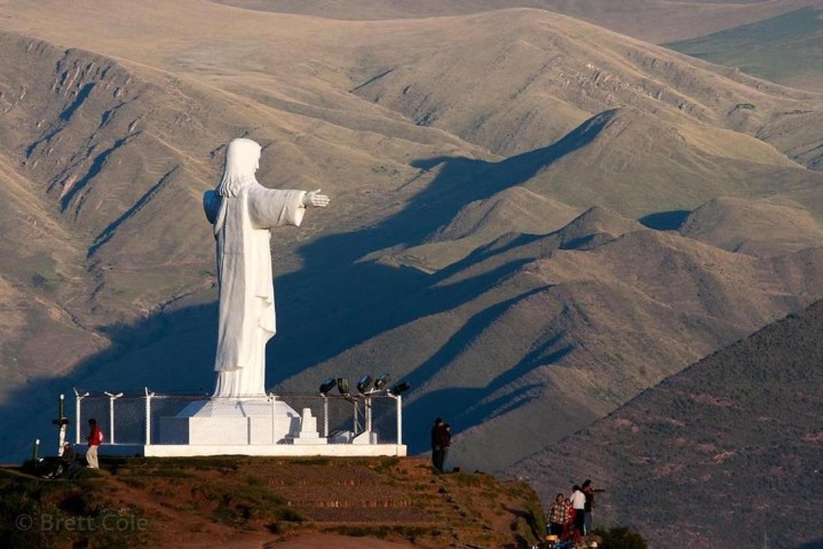 a statue on top of a hill with a mountain