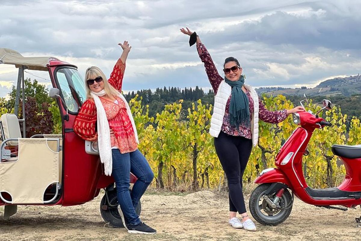 Divas sievietes stāv blakus sarkanam motorolleram