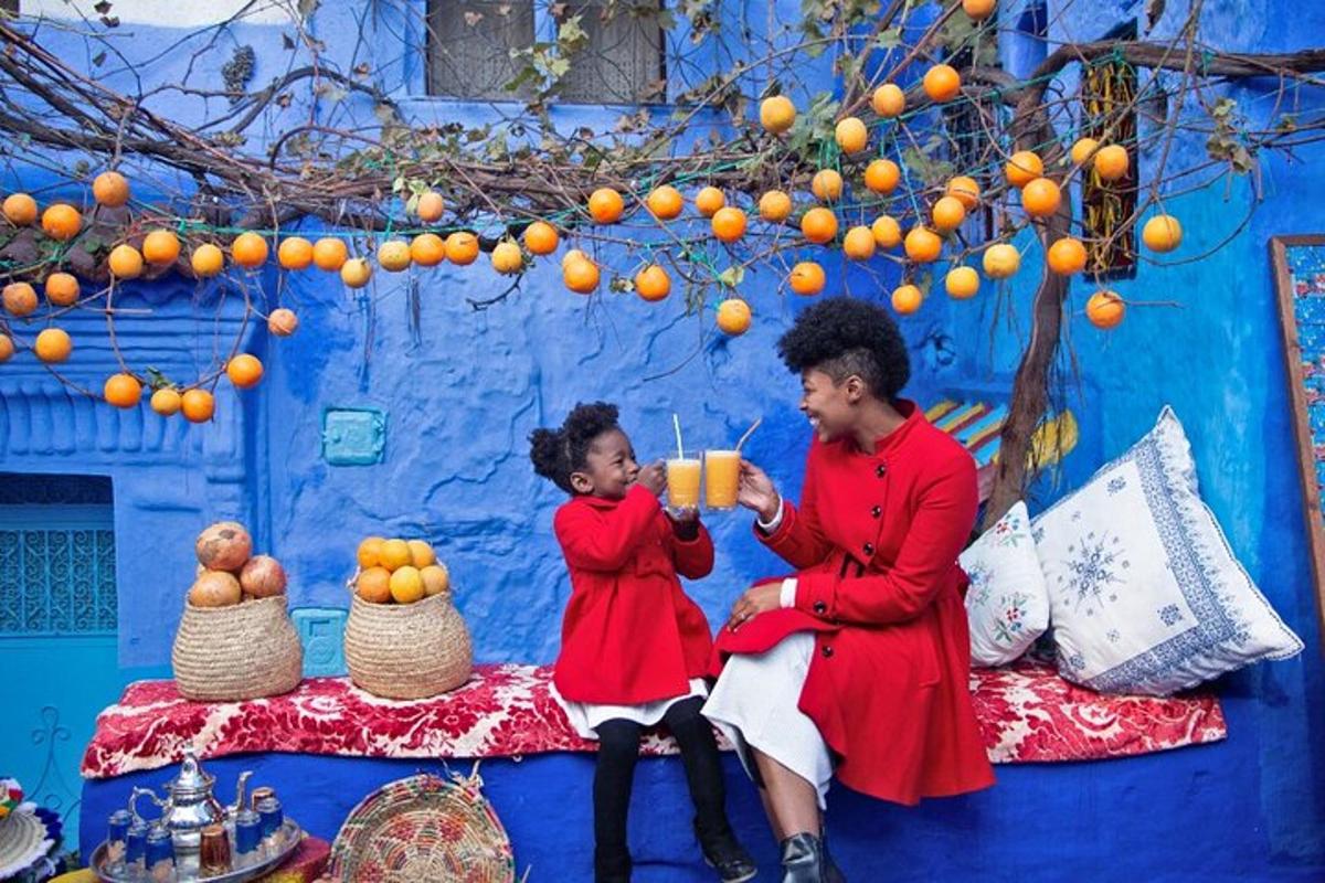 a man and a little girl sitting next to a blue wall