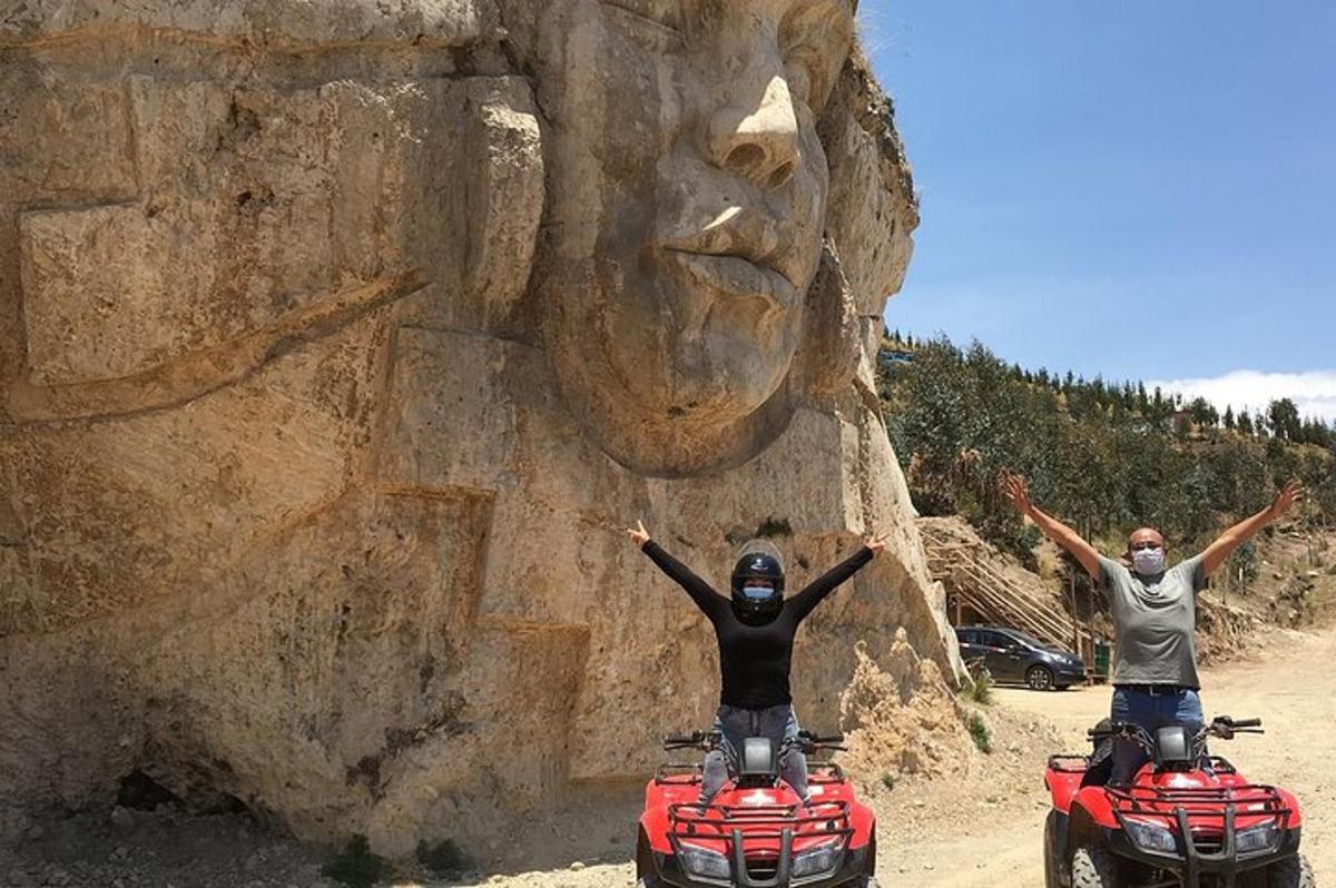 două persoane pe ATV-uri în fața unui perete de stâncă