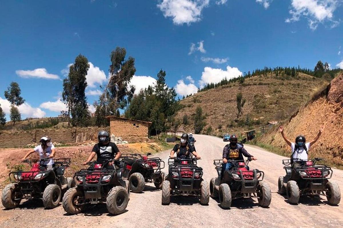 un grup de oameni care călătoresc cu ATV-uri pe un drum de pământ