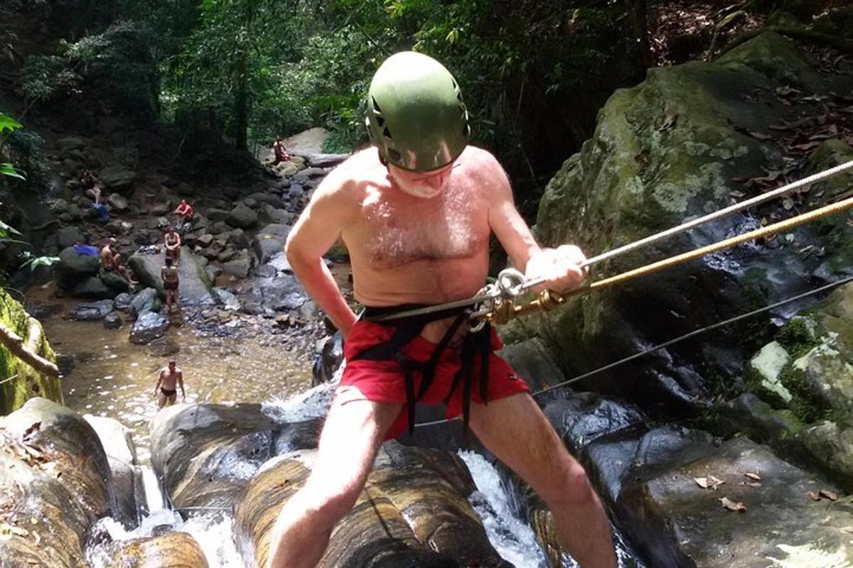 a man holding onto a rope while crossing a river