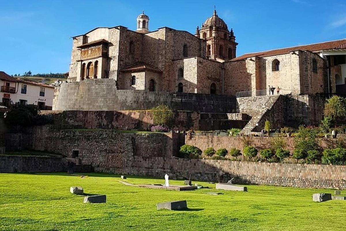 Un gran castillo con un campo verde delante de él.
