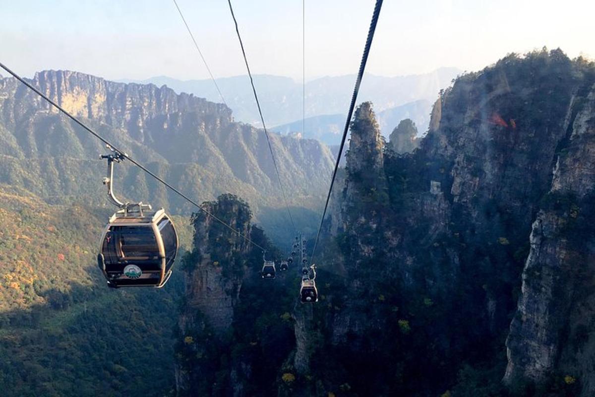a group of people riding a cable car through the mountains