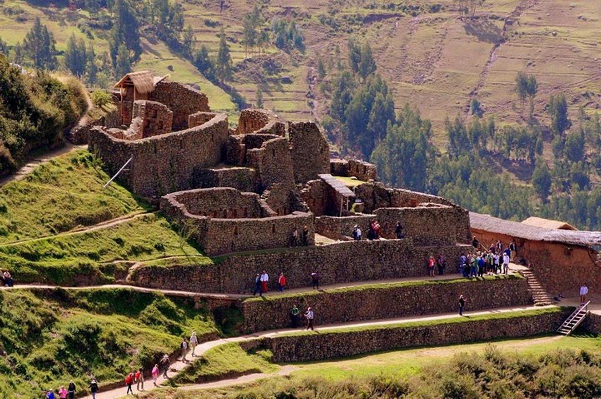 un gruppo di persone che camminano intorno a un vecchio edificio su una collina