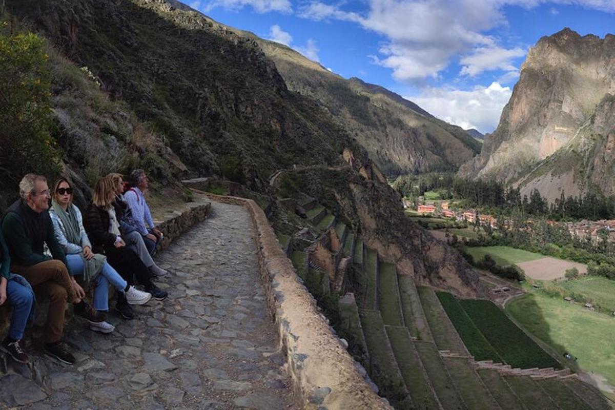 un grup de persones assegudes en un mur amb vistes a una muntanya