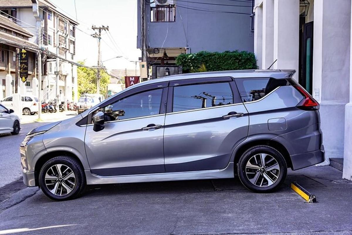 sebuah mobil kecil berwarna perak terparkir di samping sebuah gedung