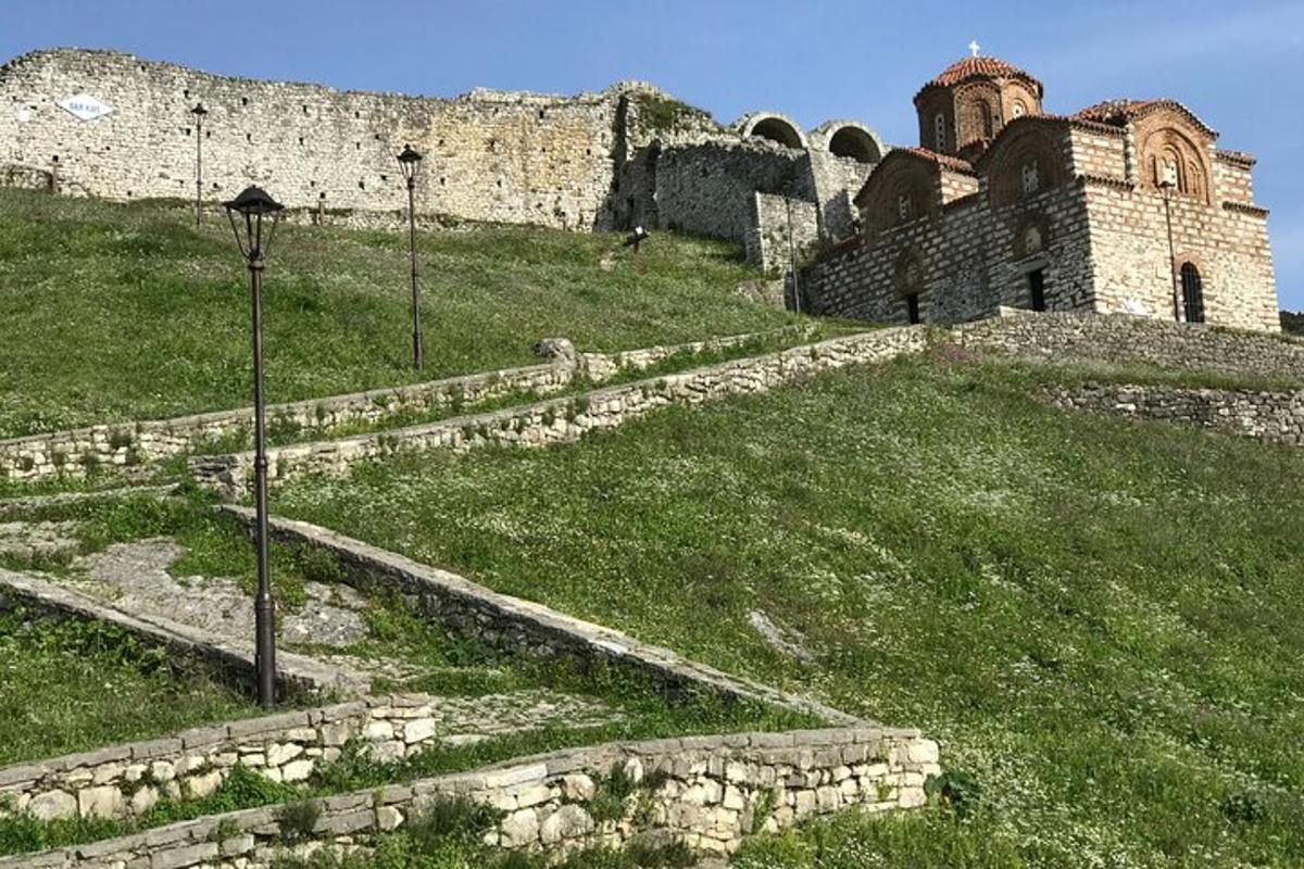 un vecchio edificio in cima a una collina erbosa