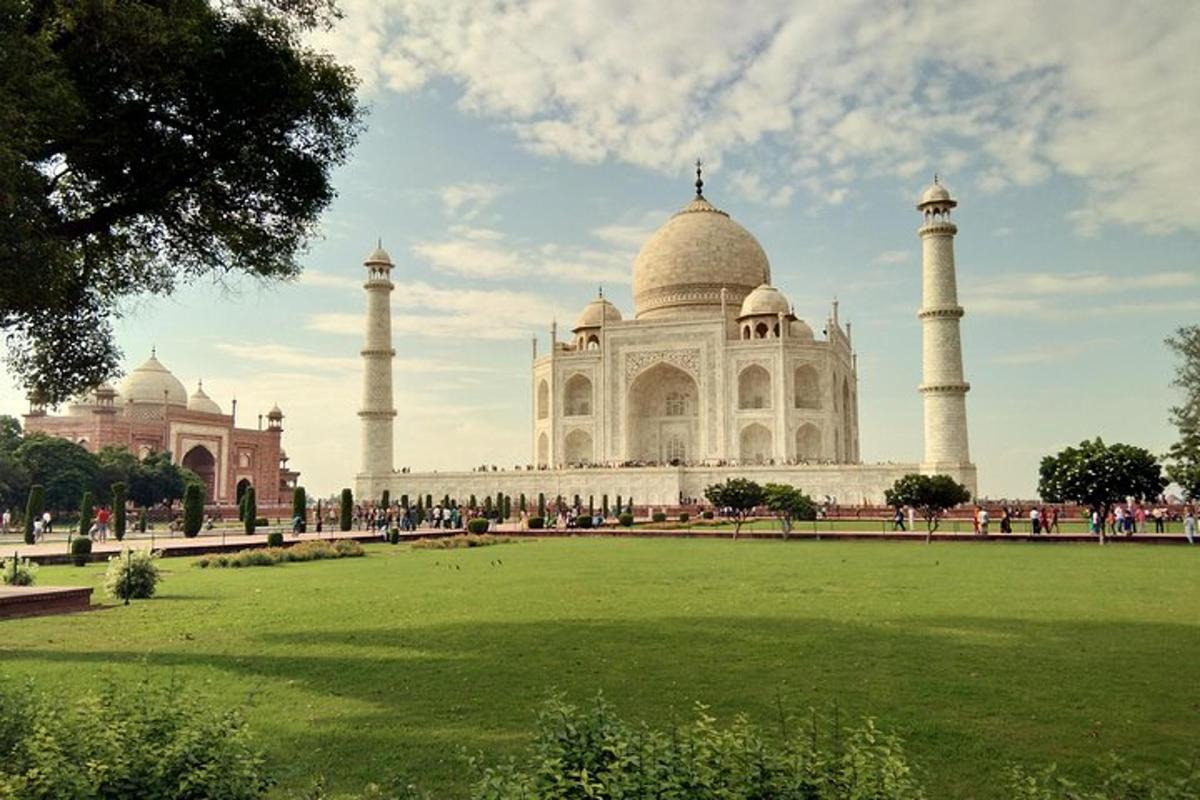 a view of the taj mahal with a green field in front