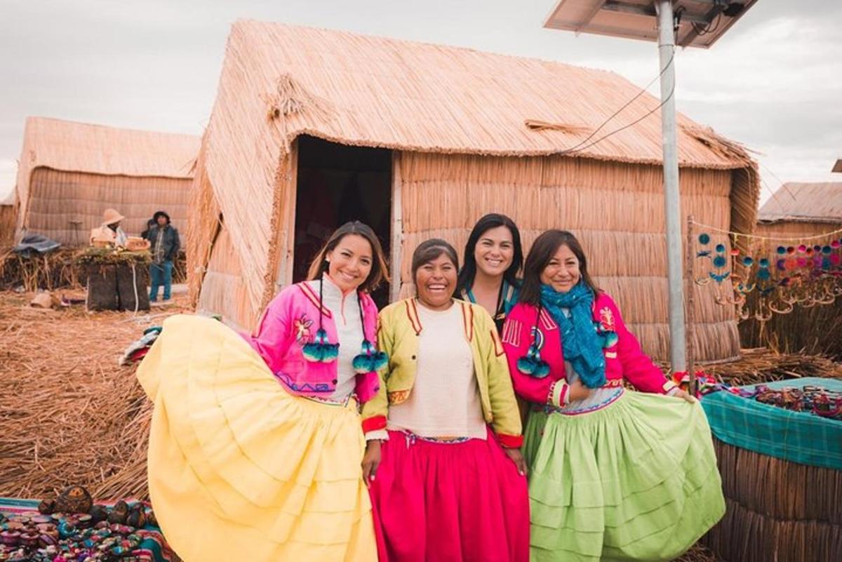 three women are standing in front of a hut