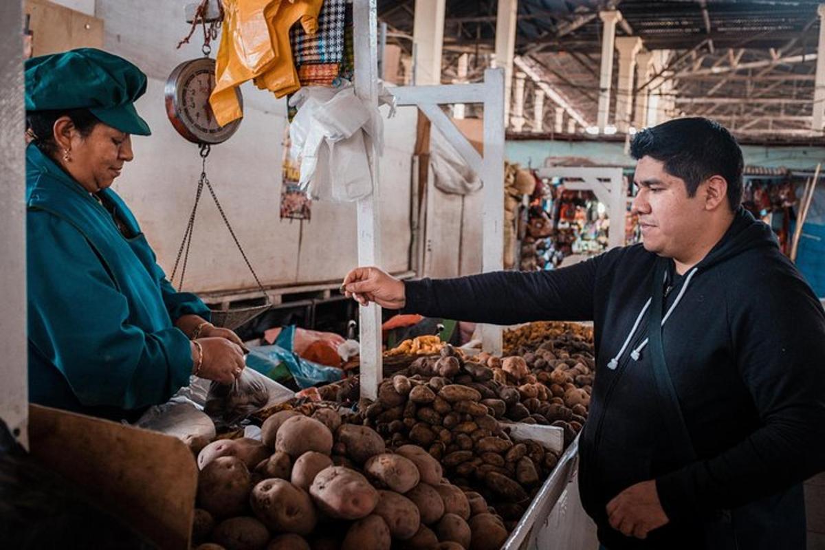 un uomo è in piedi in un mercato a vendere patate