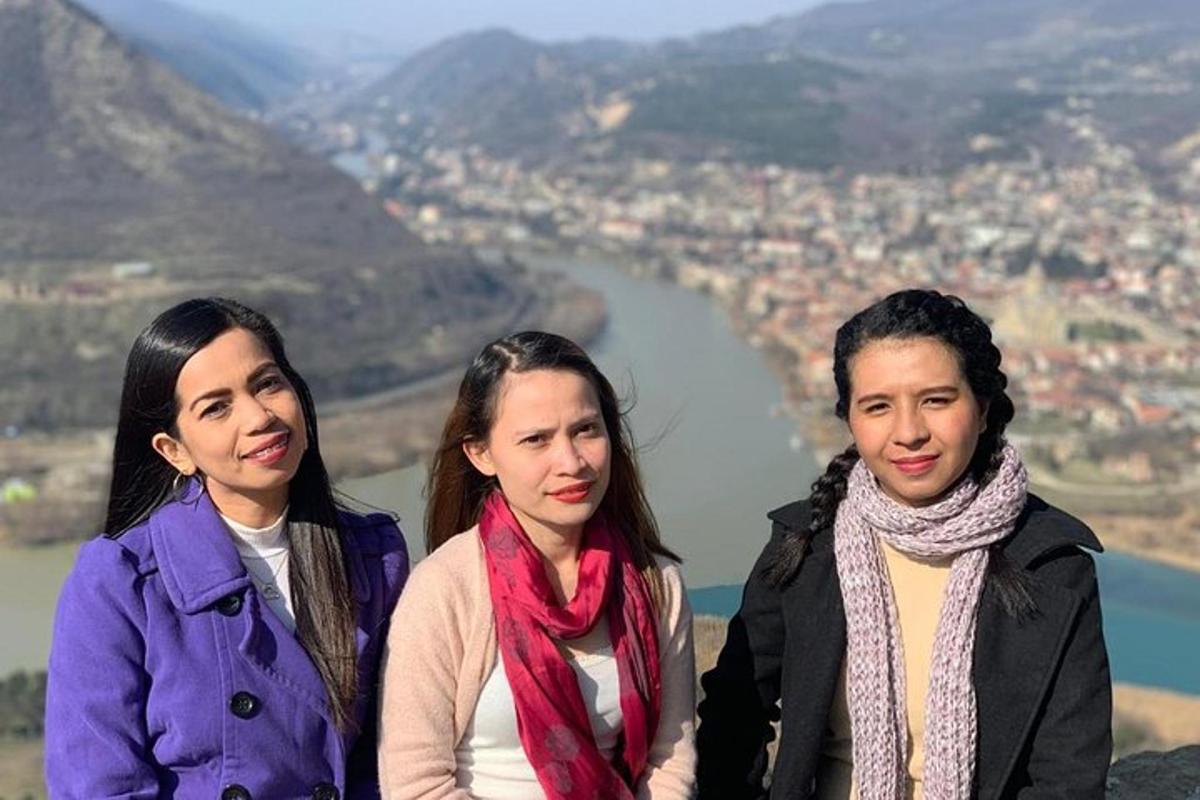 un gruppo di tre donne in piedi sulla cima di una montagna