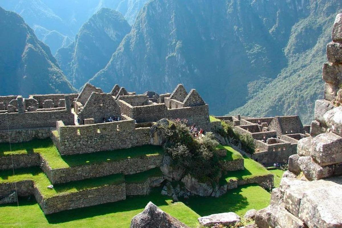 Un gran edificio de piedra con montañas al fondo.