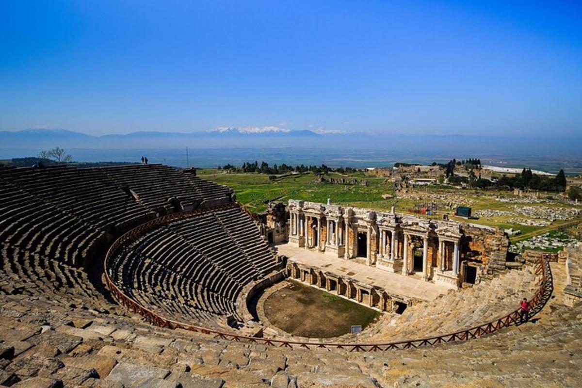 an empty amphitheater with the ocean in the background