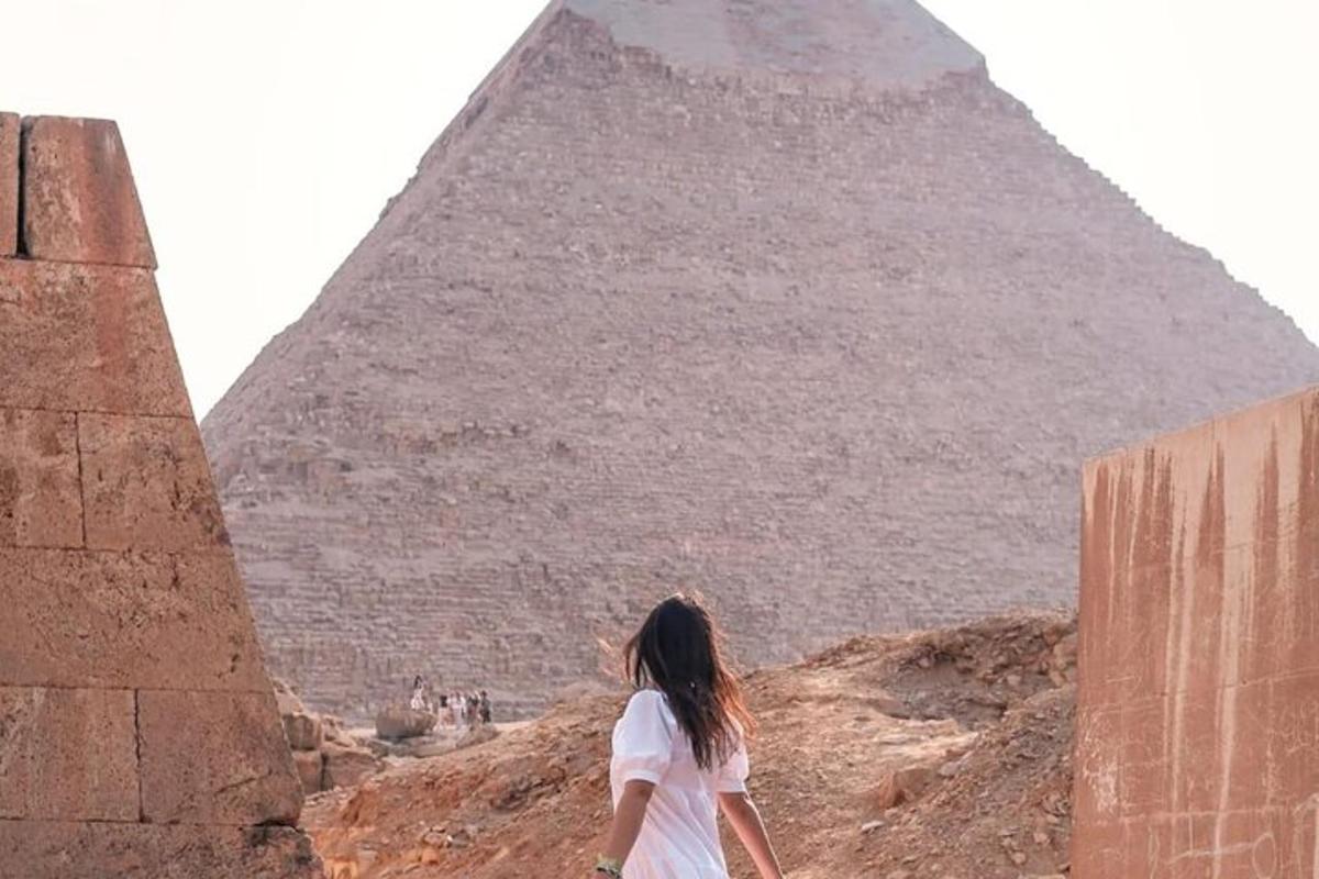 žena stojící před pyramidou