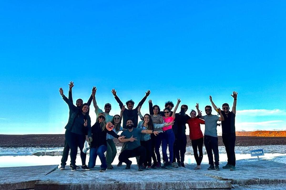 a group of people posing for a picture on the beach