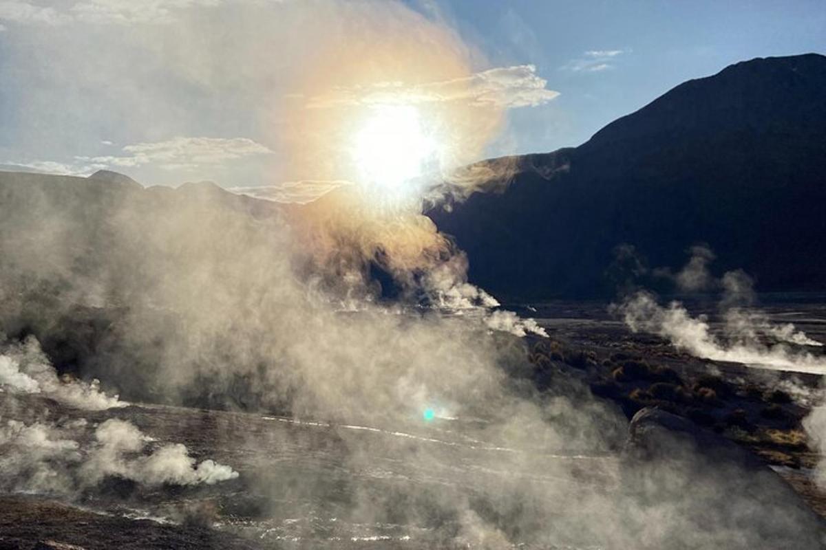 a view of the sun rising over a geyser